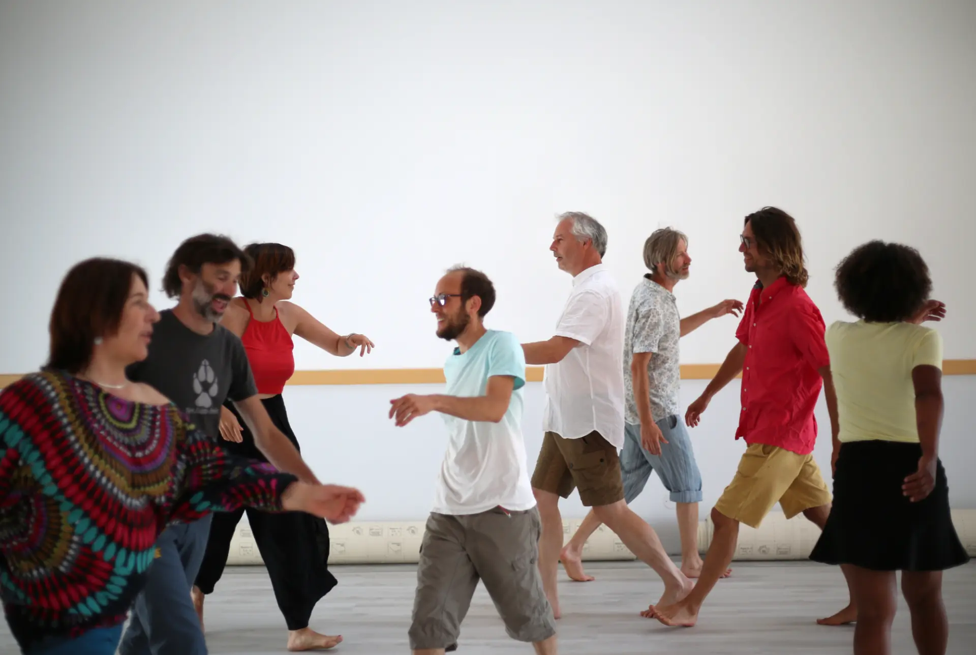 Participants d'un cours de Biodanza qui marchent dans une salle à Bédarieux après avoir reçu les consignes du facilitateur Christophe Brumbt