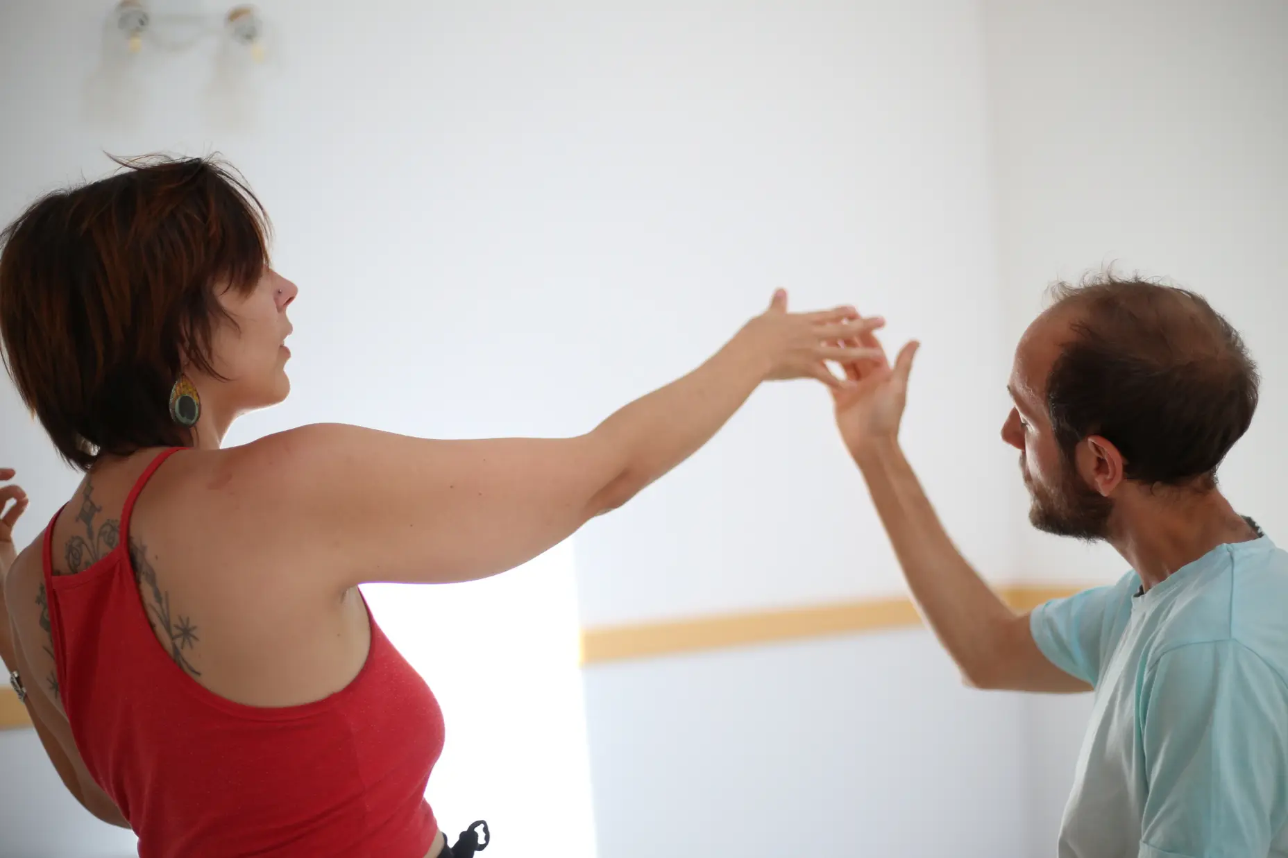 Deux danseurs partagent des mouvements lents et sensibles en toute confiance lors d'une proposition d'un cours de Biodanza