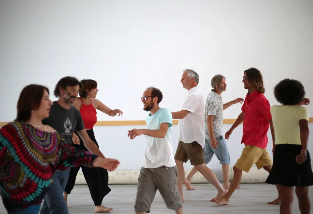 Participants d'un cours de Biodanza qui marchent dans une salle après avoir reçu les consignes du facilitateur Christophe Brumbt