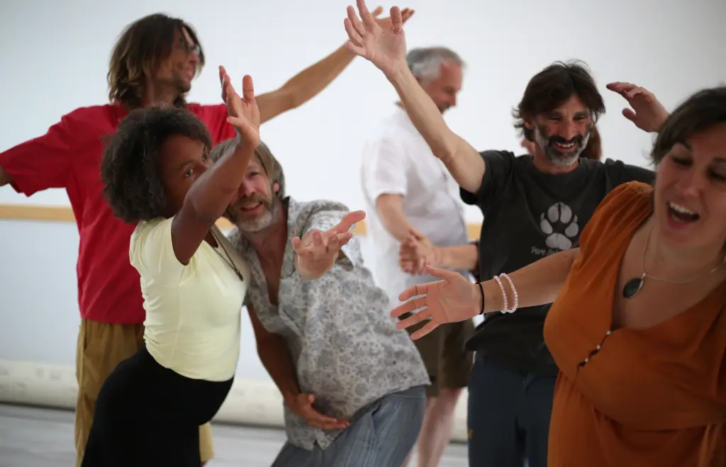 Plusieurs participants d'un cours de Biodanza facilité par Christophe Brumbt dansent librement, expriment et partagent leurs émotions grâce à la danse