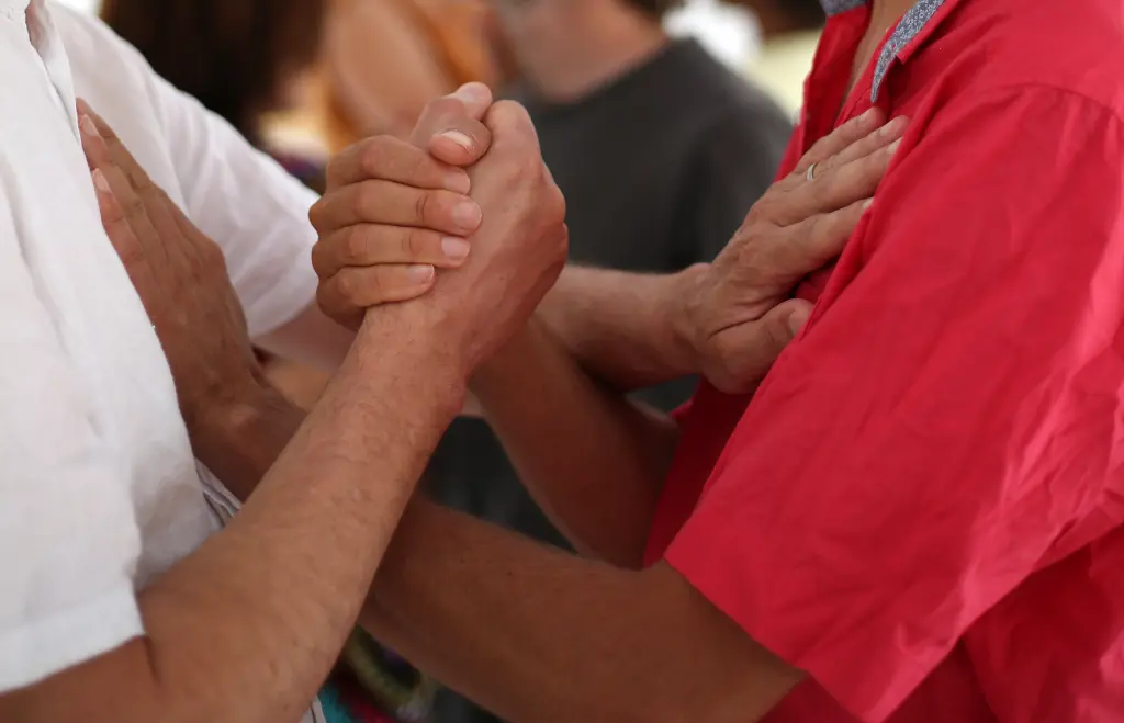 Deux personnes se rencontrent, se dévoilent, se touchent les mains et les posent sur le cœur de l'autre lors d'un cours de Biodanza à Bédarieux
